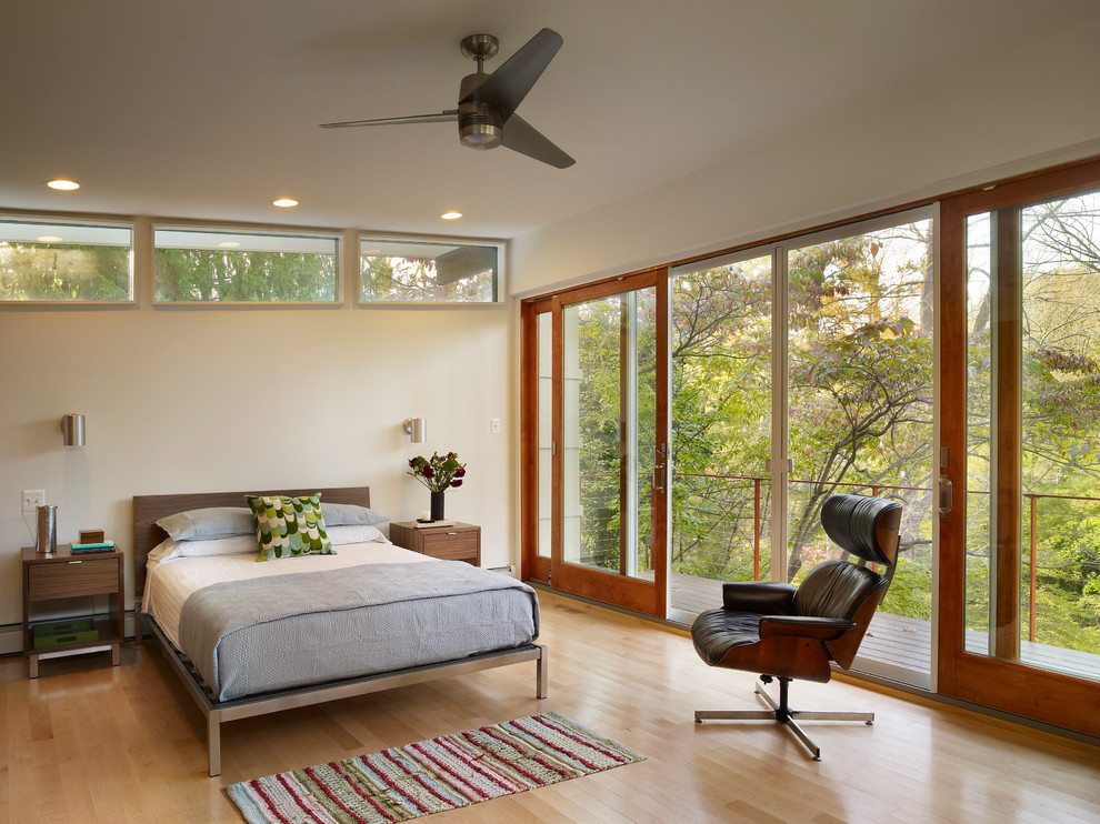Photo of a modern bedroom in Philadelphia with beige walls and light hardwood floors.