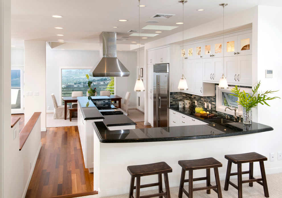 Transitional u-shaped eat-in kitchen in Hawaii with shaker cabinets, white cabinets, multi-coloured splashback and stainless steel appliances.