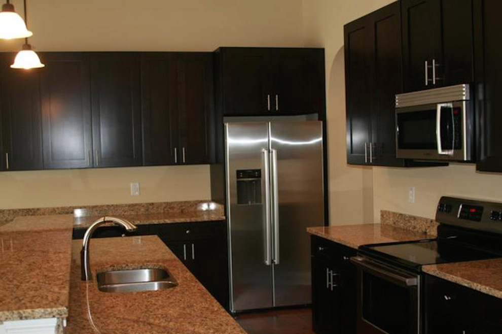 Kitchen - dark wood floor kitchen idea in Indianapolis with flat-panel cabinets, dark wood cabinets, granite countertops, stainless steel appliances and an island