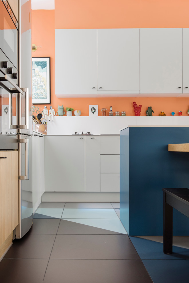 Photo of a mid-sized contemporary l-shaped eat-in kitchen in Madrid with a drop-in sink, flat-panel cabinets, blue cabinets, quartz benchtops, white splashback, stone slab splashback, stainless steel appliances, ceramic floors and with island.