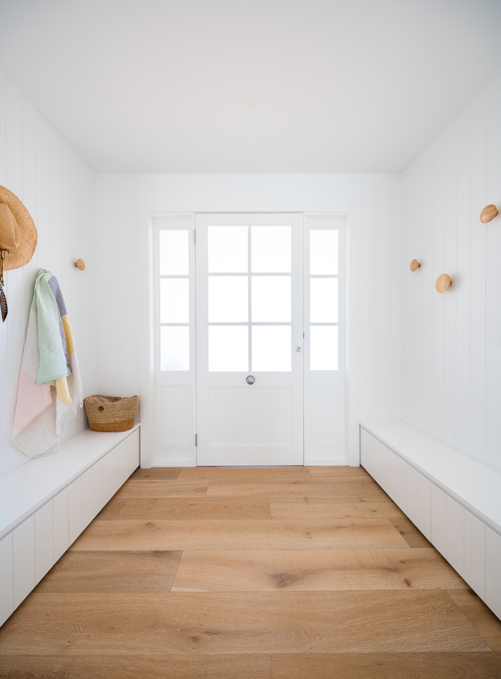 This is an example of a contemporary mudroom in Central Coast with white walls, light hardwood floors, a single front door and a white front door.