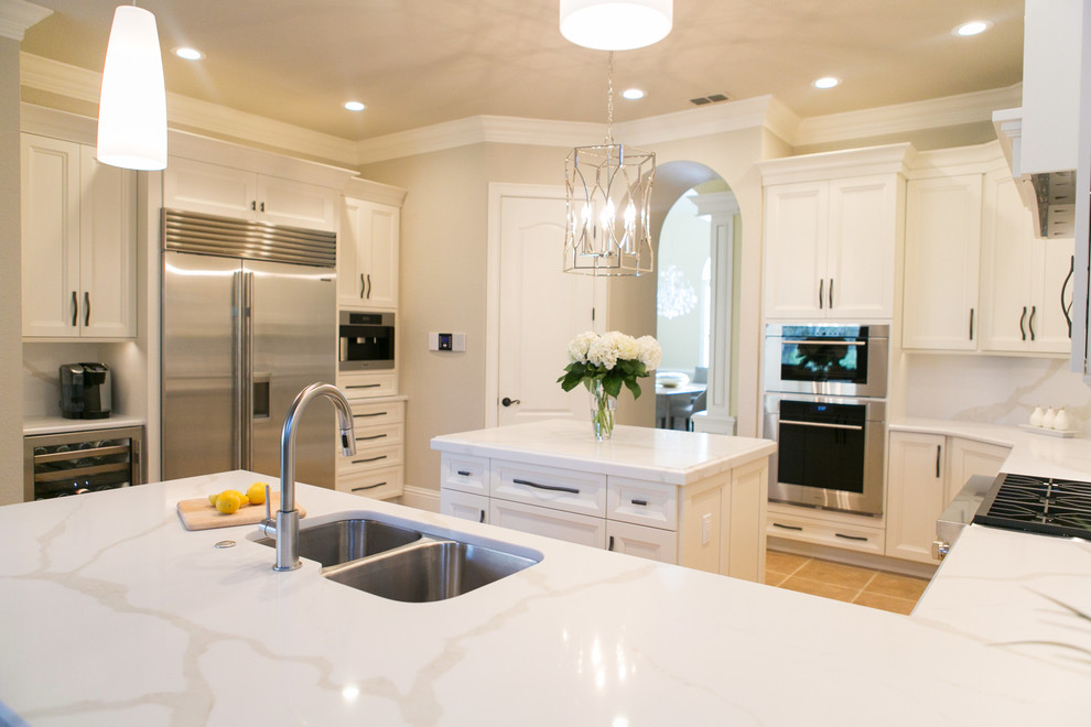 Inspiration for a mid-sized transitional u-shaped open concept kitchen remodel in Orlando with an undermount sink, recessed-panel cabinets, white cabinets, quartzite countertops, white backsplash, stone slab backsplash, stainless steel appliances and a peninsula