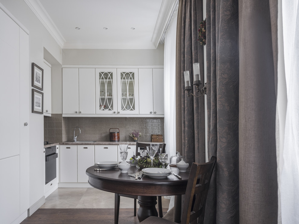 Inspiration for a transitional l-shaped open plan kitchen in Moscow with a drop-in sink, flat-panel cabinets, white cabinets, grey splashback, black appliances, no island, beige floor and grey benchtop.