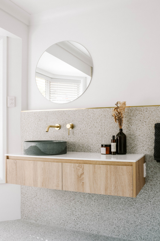 Industrial master bathroom in Gold Coast - Tweed with white walls, a vessel sink, granite benchtops, white benchtops, a single vanity, a floating vanity, ceramic tile, terrazzo floors, flat-panel cabinets, light wood cabinets, gray tile and grey floor.