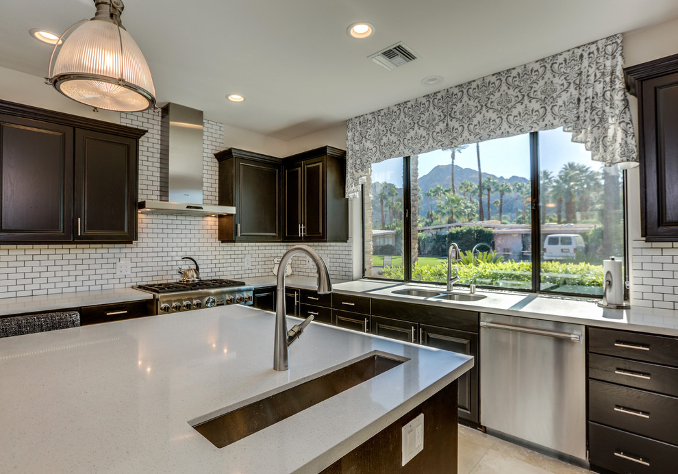 Inspiration for a mid-sized transitional u-shaped travertine floor and brown floor eat-in kitchen remodel with an undermount sink, raised-panel cabinets, black cabinets, quartz countertops, white backsplash, subway tile backsplash, stainless steel appliances, an island and gray countertops