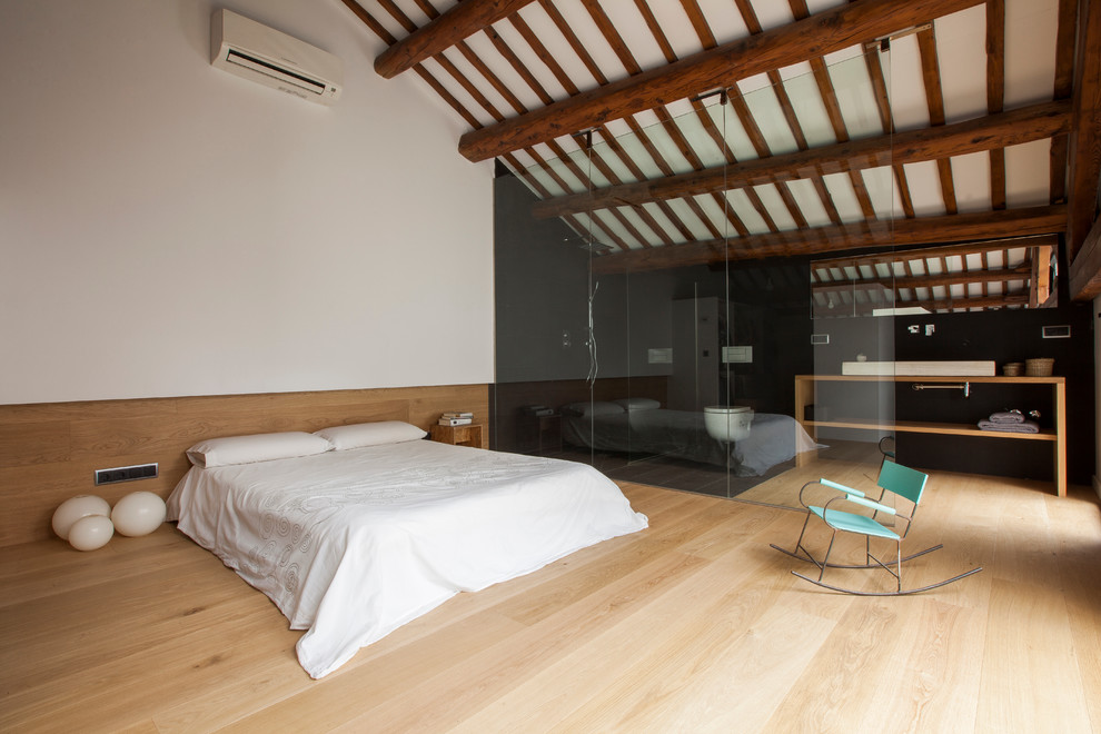 This is an example of a large country master bedroom in Barcelona with multi-coloured walls, light hardwood floors and no fireplace.