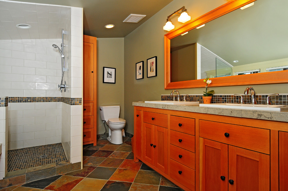 Design ideas for an arts and crafts master bathroom in Seattle with a drop-in sink, shaker cabinets, medium wood cabinets, a drop-in tub, an alcove shower, a two-piece toilet, multi-coloured tile, grey walls and slate floors.