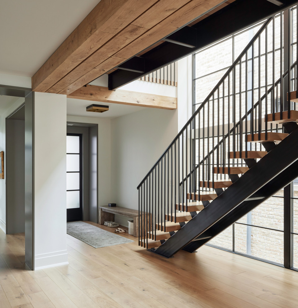 This is an example of a modern wood straight staircase in Chicago with open risers and metal railing.