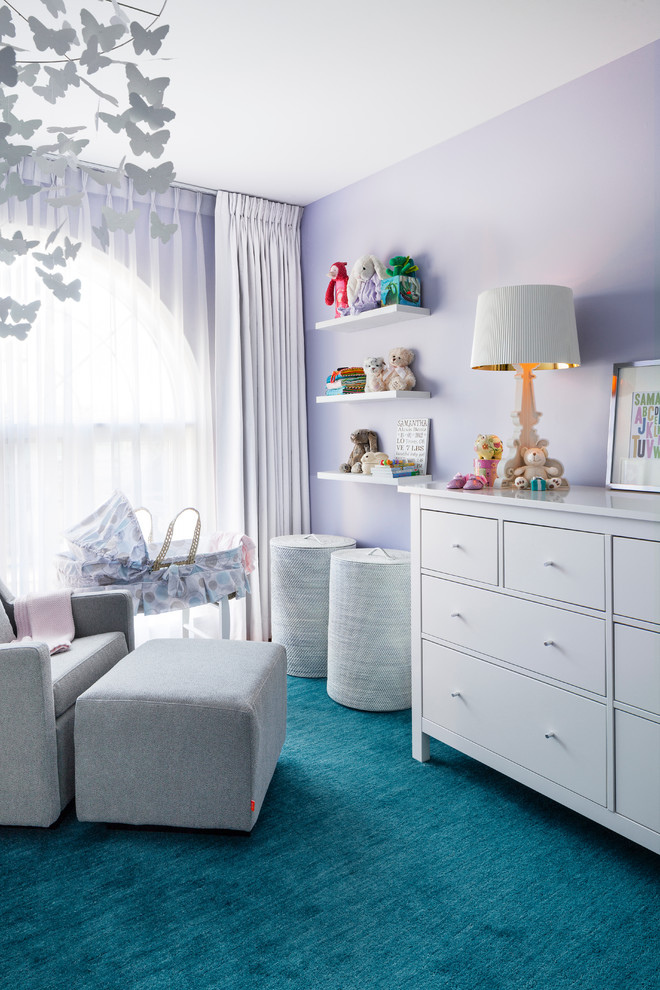 Transitional nursery in Toronto with purple walls and carpet for girls.