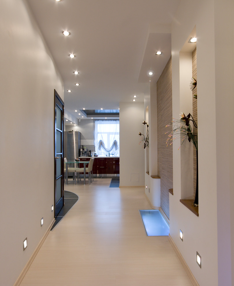 This is an example of a contemporary hallway in Melbourne with white walls and beige floor.