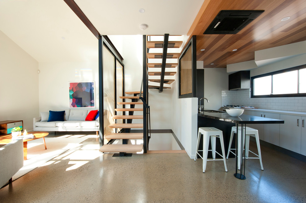 Photo of a mid-sized contemporary wood u-shaped staircase in Melbourne with open risers.