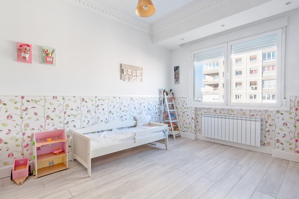 Photo of a mid-sized transitional kids' bedroom for kids 4-10 years old and girls in Madrid with multi-coloured walls and painted wood floors.
