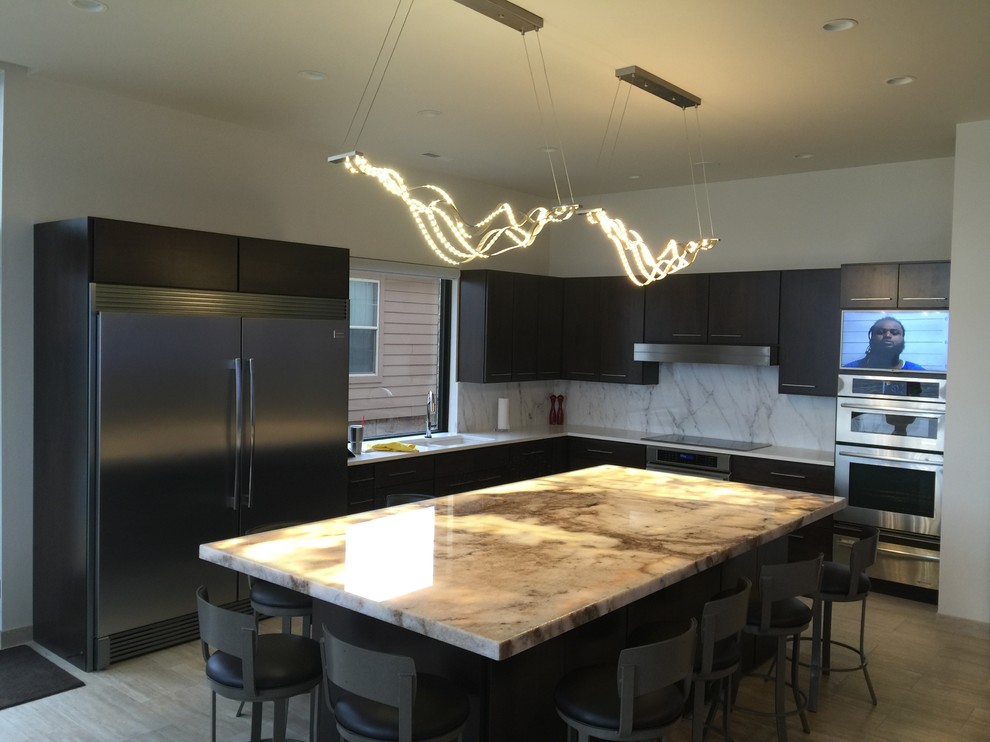 Example of a mid-sized transitional l-shaped light wood floor and beige floor open concept kitchen design with an undermount sink, flat-panel cabinets, dark wood cabinets, marble countertops, white backsplash, marble backsplash, stainless steel appliances and an island