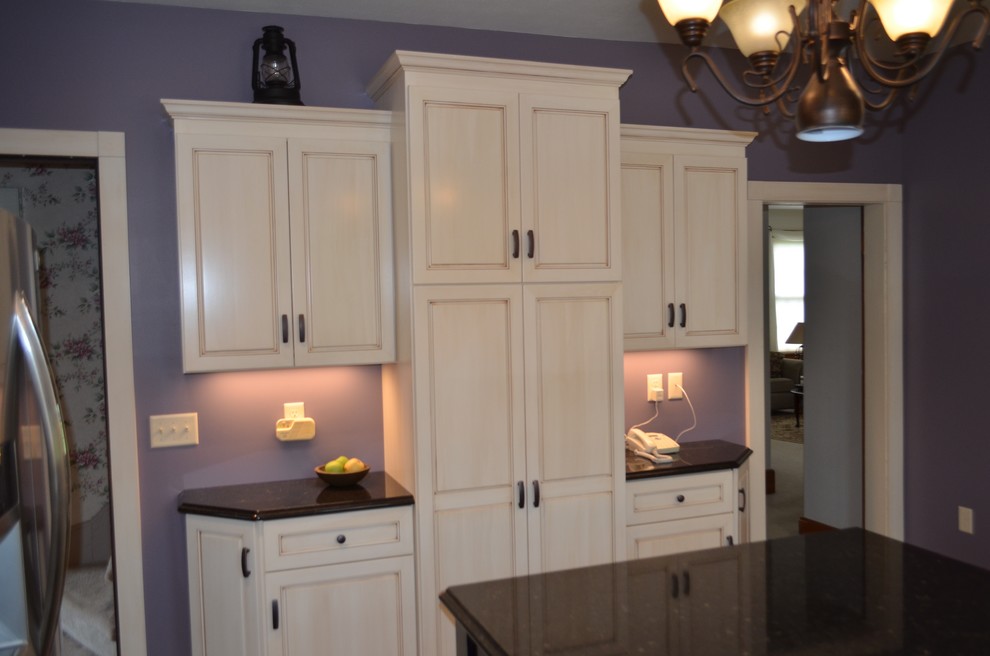 Mid-sized transitional u-shaped brown floor eat-in kitchen photo with a double-bowl sink, recessed-panel cabinets, light wood cabinets, solid surface countertops, white backsplash, stone tile backsplash, stainless steel appliances and an island