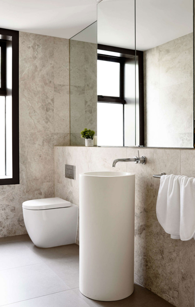 Foto di una stanza da bagno design con piastrelle beige, lavabo a colonna e un lavabo