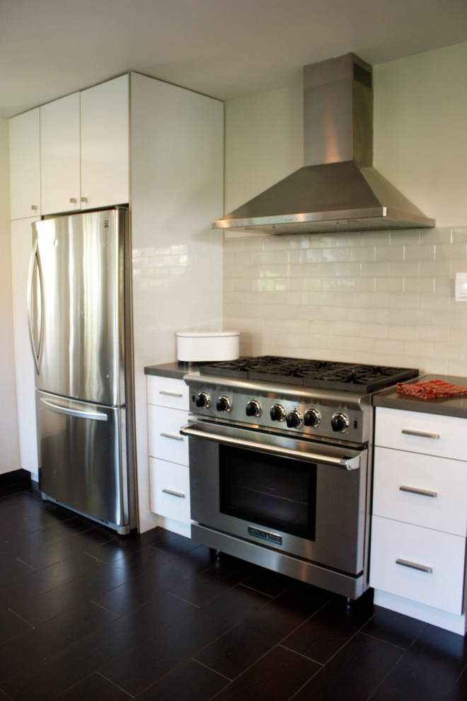 Photo of a mid-sized modern l-shaped separate kitchen in San Francisco with an undermount sink, flat-panel cabinets, white cabinets, quartz benchtops, grey splashback, ceramic splashback, stainless steel appliances and ceramic floors.