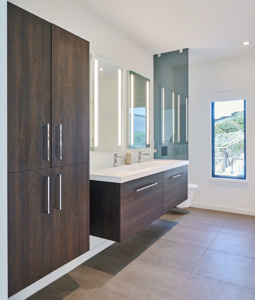 Medium sized scandi ensuite bathroom in San Francisco with flat-panel cabinets, medium wood cabinets, a corner bath, a shower/bath combination, a one-piece toilet, white walls, a submerged sink, engineered stone worktops, beige floors, a hinged door, white worktops, double sinks and a built in vanity unit.