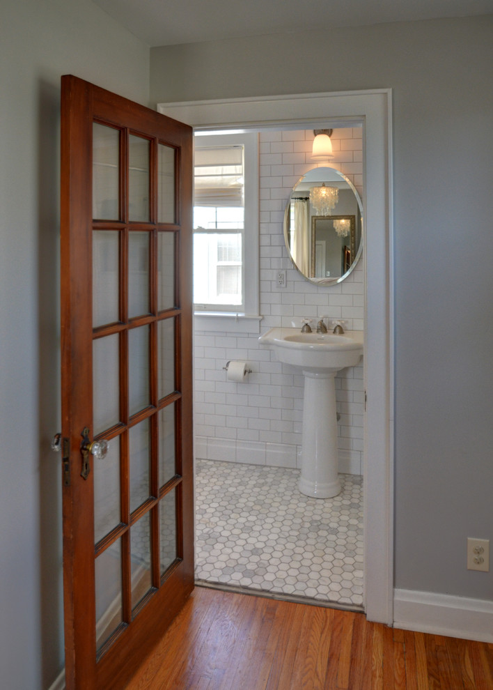 This is an example of a small master bathroom in Columbus with a pedestal sink, recessed-panel cabinets, grey cabinets, a one-piece toilet, white tile, white walls and marble floors.