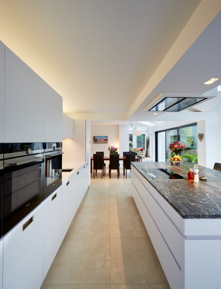 Inspiration for a mid-sized contemporary single-wall eat-in kitchen in Other with flat-panel cabinets, white cabinets, granite benchtops, metallic splashback, mirror splashback, panelled appliances, with island and blue benchtop.