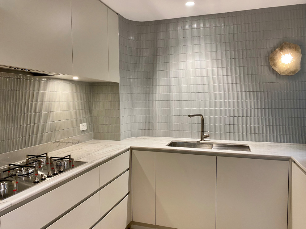 Kleine Moderne Küche in U-Form mit Einbauwaschbecken, Rückwand aus Mosaikfliesen, Küchengeräten aus Edelstahl und hellem Holzboden in Melbourne