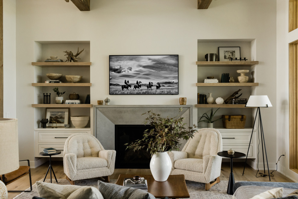 Imagen de salón abierto y abovedado clásico renovado de tamaño medio con paredes grises, suelo de madera clara, todas las chimeneas, marco de chimenea de hormigón y televisor colgado en la pared