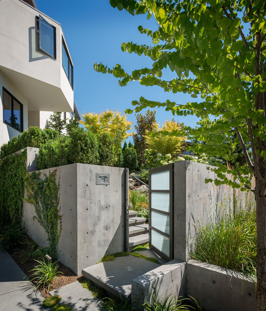 This is an example of a mid-sized modern full sun garden for summer in Seattle with concrete pavers.