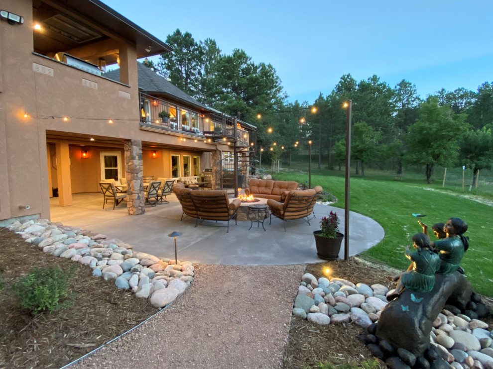 Photo of a large traditional backyard patio in Denver with a fire feature, concrete slab and a roof extension.