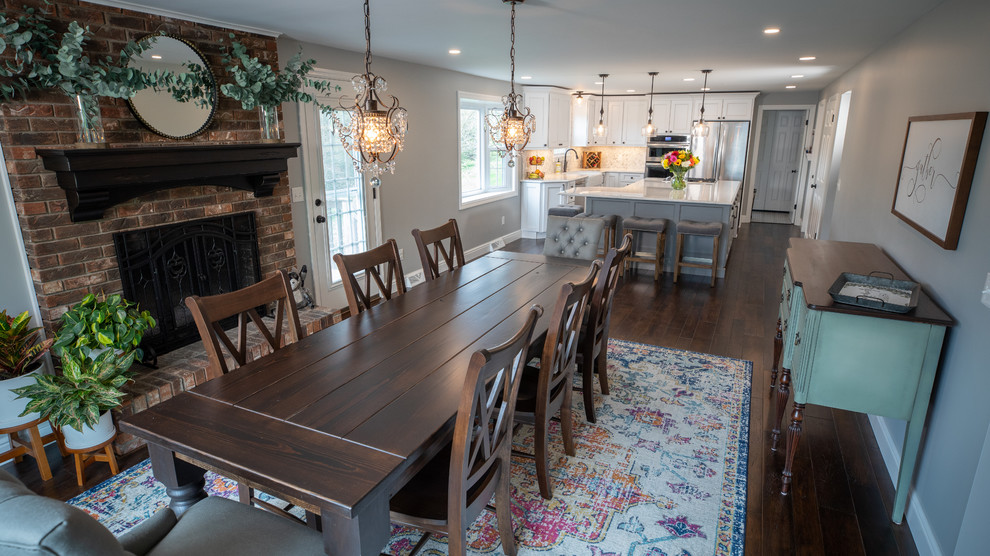 Mid-sized transitional kitchen/dining combo in Other with grey walls, dark hardwood floors, no fireplace, a brick fireplace surround and brown floor.
