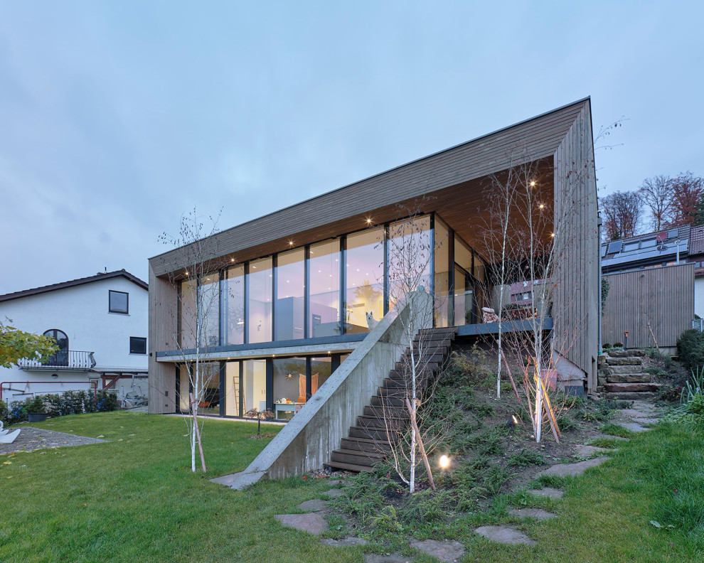 Idee per la facciata di una casa con rivestimento in legno, tetto piano, copertura verde e pannelli sovrapposti