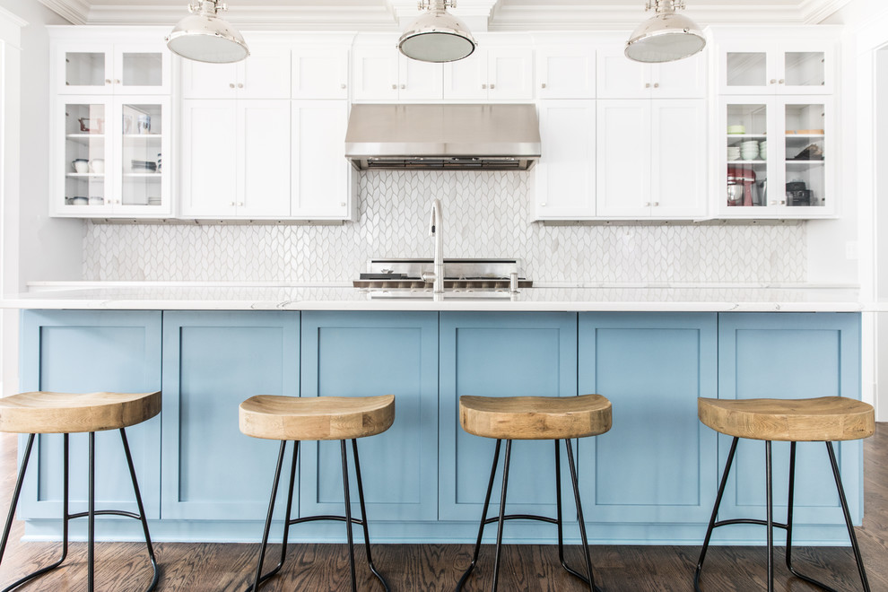 Inspiration for a mid-sized beach style l-shaped open plan kitchen in Charlotte with an undermount sink, shaker cabinets, white cabinets, white splashback, stainless steel appliances, dark hardwood floors, with island, brown floor, marble benchtops and ceramic splashback.