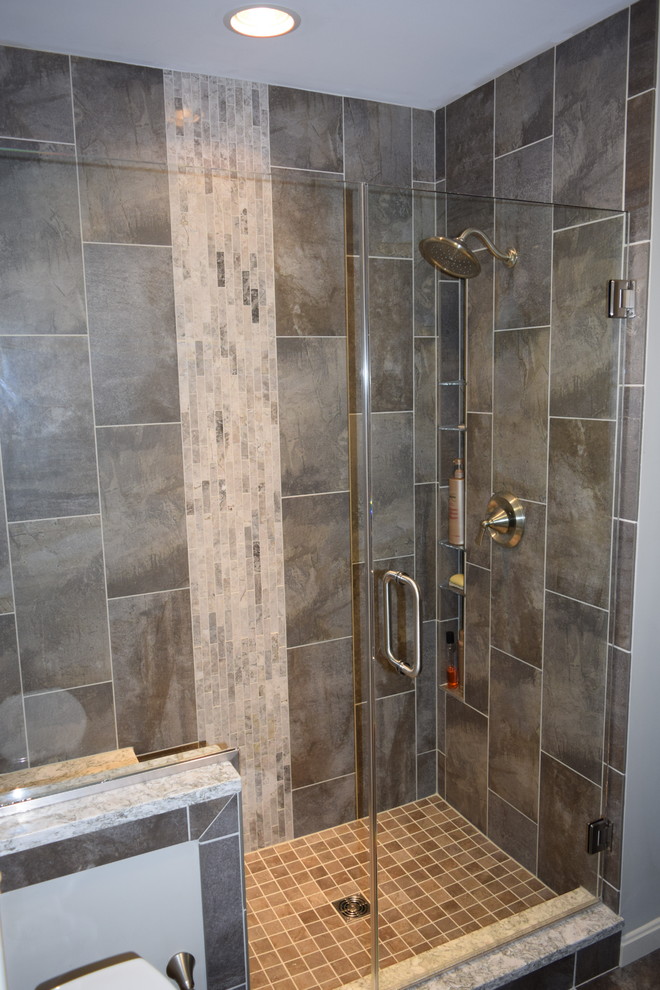 Photo of a contemporary bathroom in Other with recessed-panel cabinets, dark wood cabinets, gray tile, ceramic tile, ceramic floors, a vessel sink and engineered quartz benchtops.