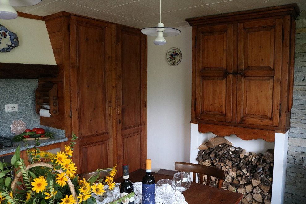 Immagine di una cucina abitabile stile rurale con ante in legno chiaro