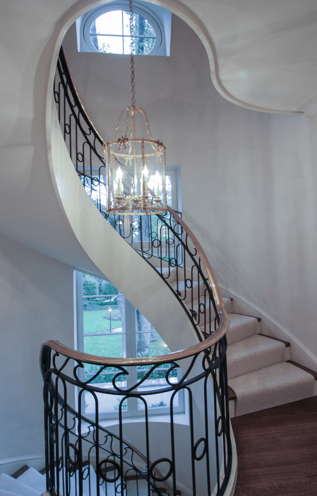 Inspiration for a large transitional wooden curved metal railing staircase remodel in DC Metro with wooden risers