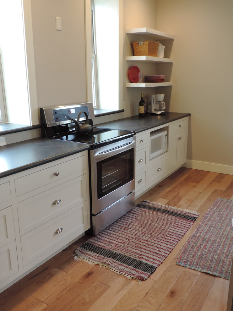 Mid-sized mountain style single-wall light wood floor eat-in kitchen photo with a double-bowl sink, shaker cabinets, white cabinets, quartz countertops, stainless steel appliances and an island