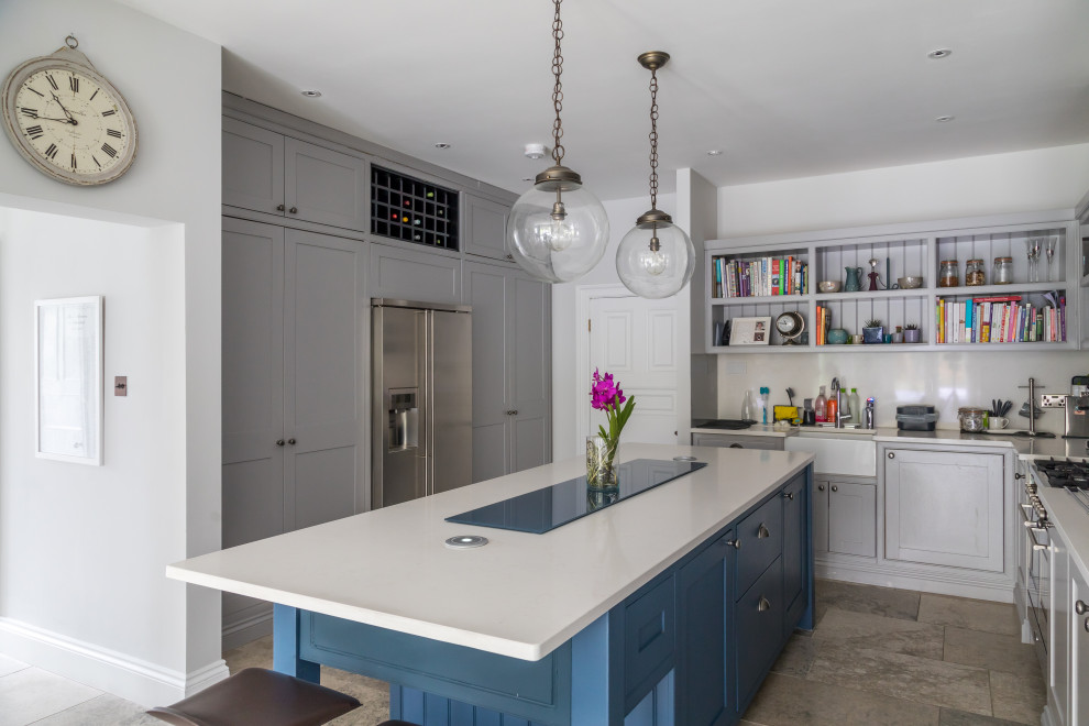 This is an example of a transitional u-shaped kitchen in Other with a farmhouse sink, beaded inset cabinets, grey cabinets, stainless steel appliances, with island, grey floor and white benchtop.
