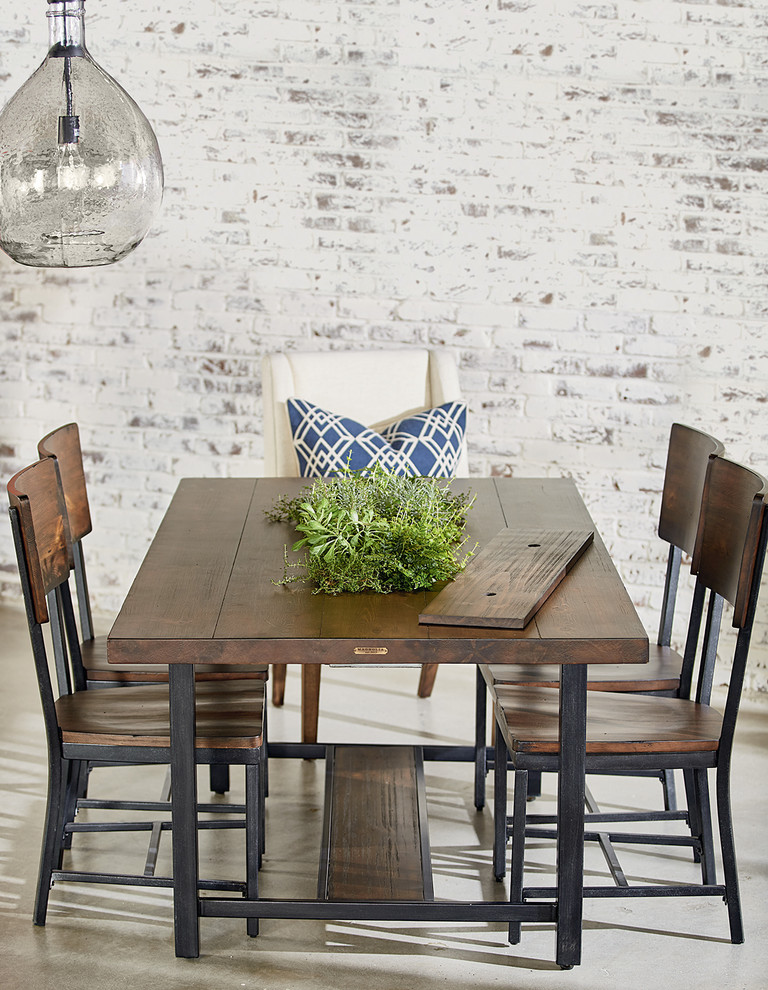 Photo of an industrial dining room in Houston with white walls, concrete floors and no fireplace.