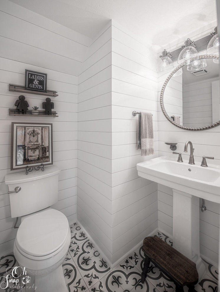Kleine Country Gästetoilette mit Wandtoilette mit Spülkasten, weißer Wandfarbe, Porzellan-Bodenfliesen, Sockelwaschbecken, buntem Boden und Holzdielenwänden in Houston