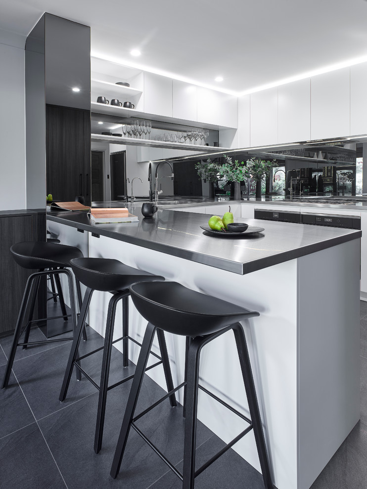 Large modern u-shaped eat-in kitchen in Other with an integrated sink, white cabinets, stainless steel benchtops, glass sheet splashback, stainless steel appliances, ceramic floors and a peninsula.