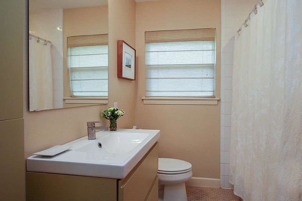 Photo of a small midcentury 3/4 bathroom in Houston with furniture-like cabinets, green cabinets, a drop-in tub, a shower/bathtub combo, a two-piece toilet, beige tile, mosaic tile, beige walls, mosaic tile floors, a wall-mount sink and solid surface benchtops.