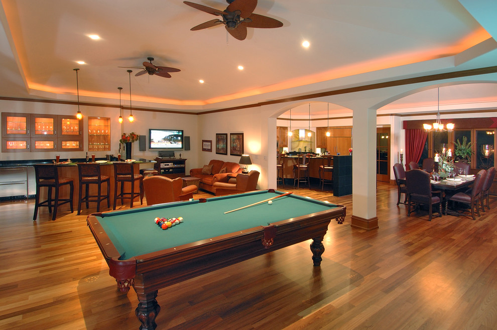 This is an example of an expansive contemporary open concept family room in Hawaii with white walls, medium hardwood floors, no tv and brown floor.