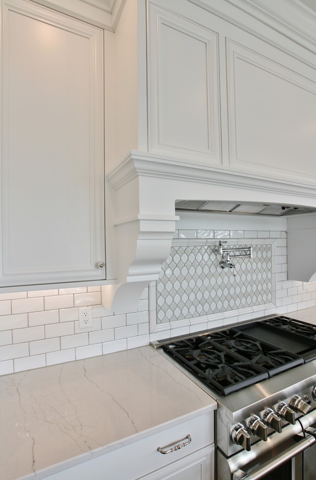 Example of a transitional kitchen design with a farmhouse sink, flat-panel cabinets, quartz countertops and paneled appliances