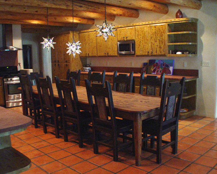 Large mountain style l-shaped terra-cotta tile and red floor eat-in kitchen photo in Albuquerque with flat-panel cabinets, distressed cabinets, no island, an undermount sink, concrete countertops, metallic backsplash, mosaic tile backsplash and stainless steel appliances