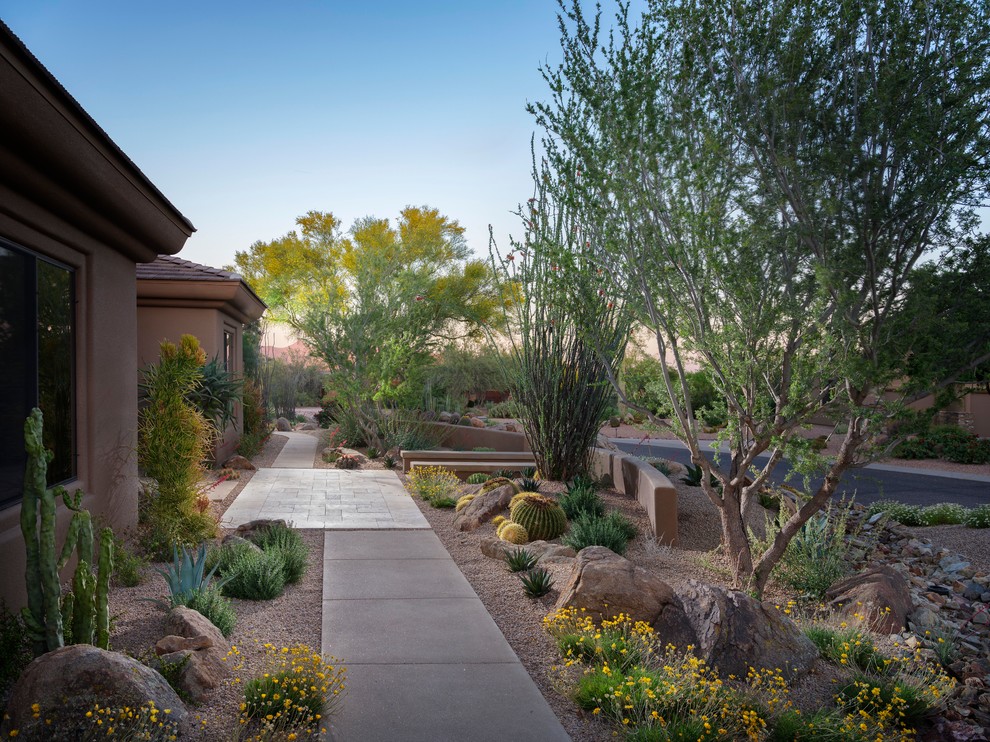 This is an example of a mid-sized front yard xeriscape in Phoenix with gravel.