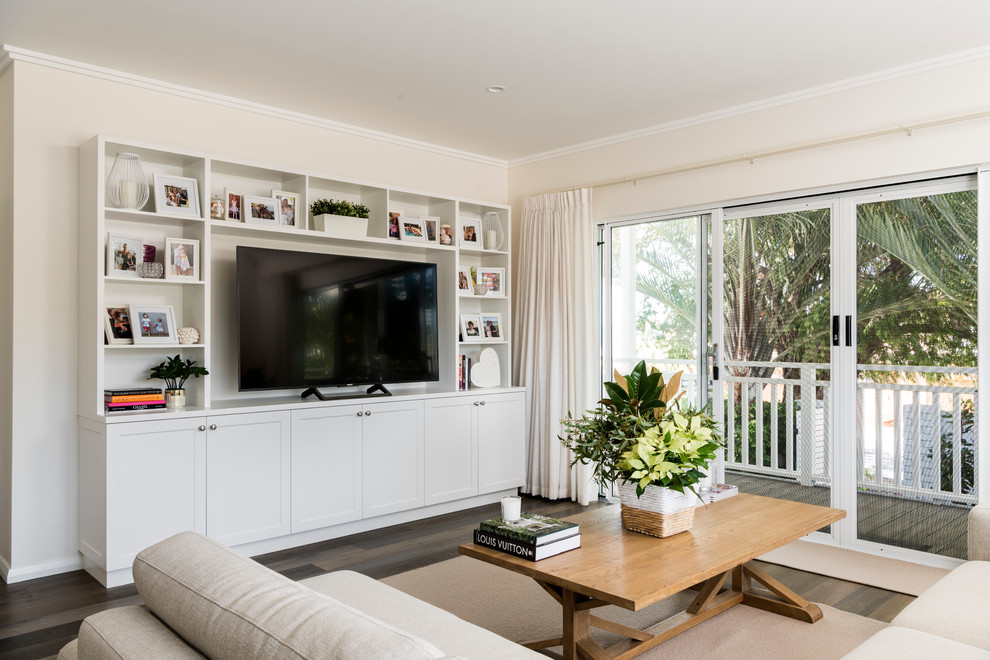 This is an example of a beach style living room in Perth with beige walls, dark hardwood floors, a freestanding tv and brown floor.