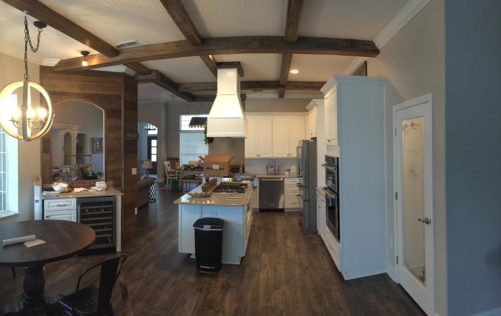 Large transitional l-shaped dark wood floor and brown floor enclosed kitchen photo in Tampa with raised-panel cabinets, white cabinets, stainless steel appliances and an island