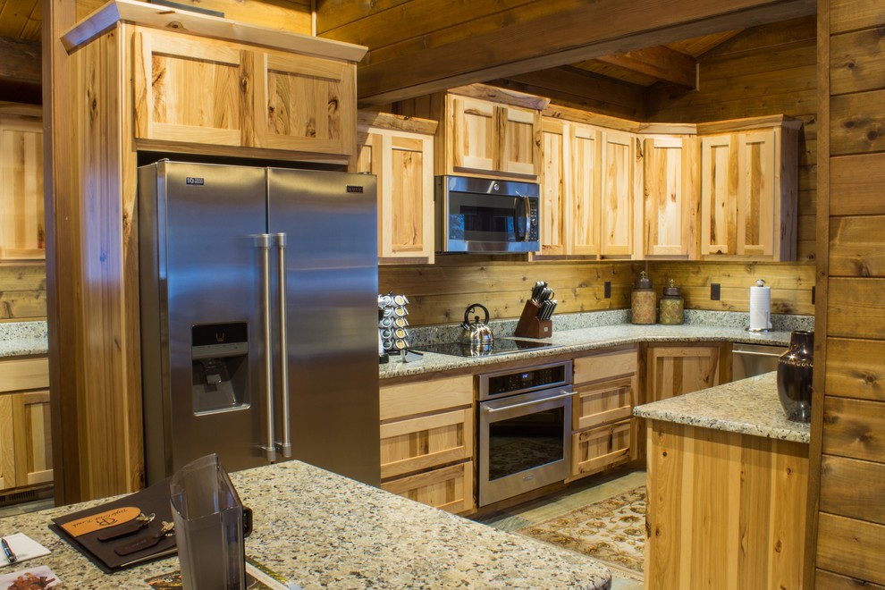 Mid-sized country u-shaped eat-in kitchen in Other with flat-panel cabinets, medium wood cabinets, granite benchtops, stainless steel appliances, slate floors, with island, an undermount sink and grey floor.
