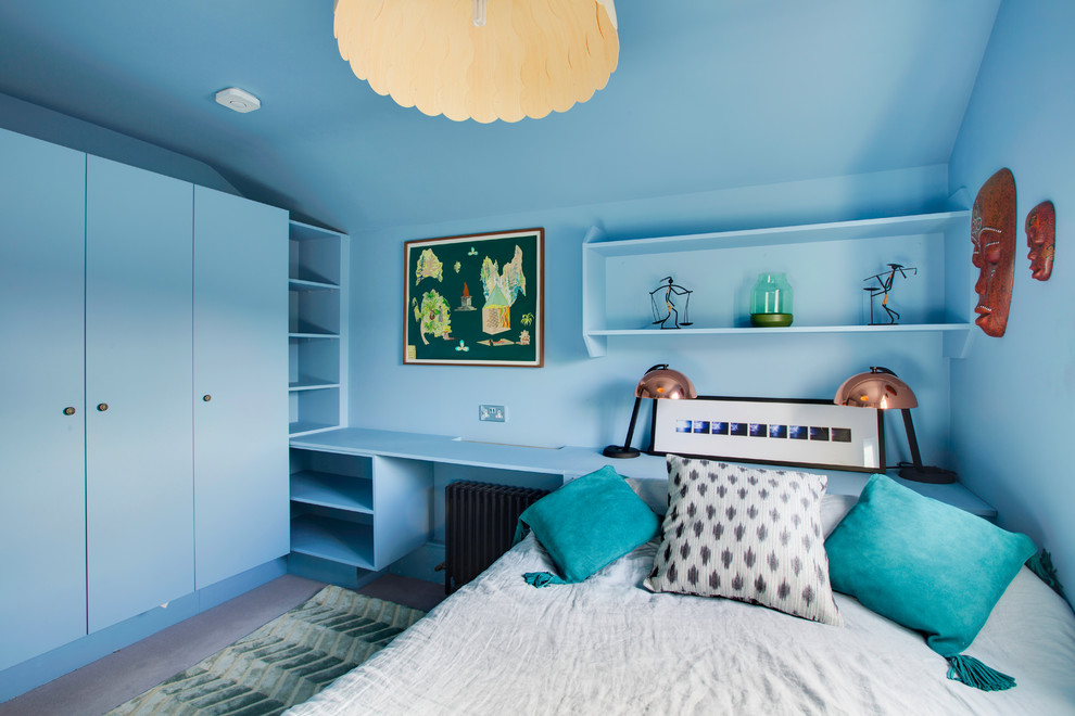 Photo of a mid-sized contemporary guest bedroom in London with blue walls and carpet.