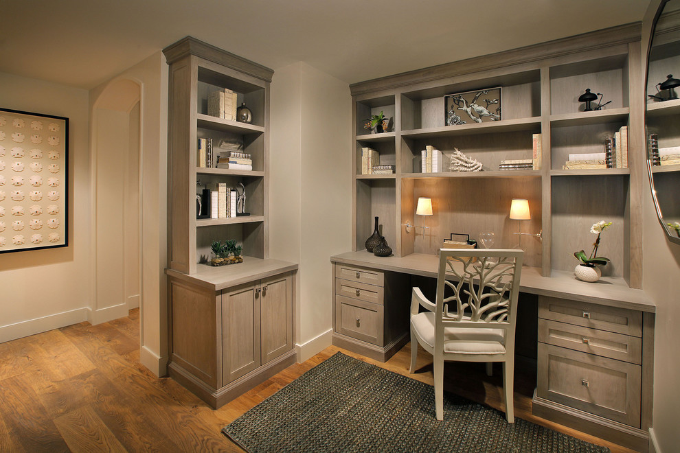 This is an example of a mid-sized traditional study room in Miami with beige walls, medium hardwood floors, a built-in desk, no fireplace and brown floor.