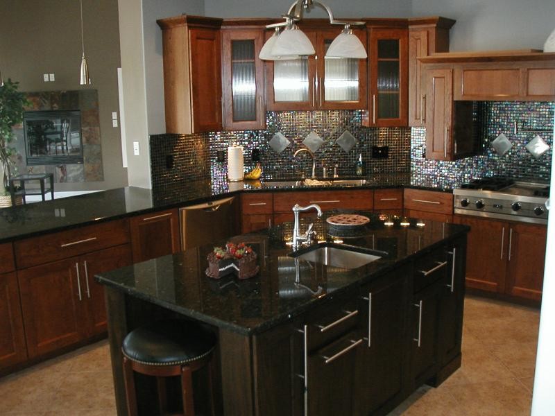 Inspiration for a mid-sized timeless l-shaped travertine floor and beige floor enclosed kitchen remodel with an undermount sink, shaker cabinets, dark wood cabinets, granite countertops, metallic backsplash, mosaic tile backsplash, stainless steel appliances and an island