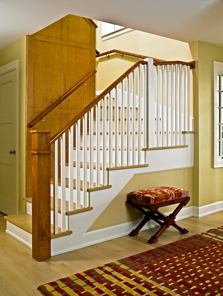 This is an example of a small transitional wood straight staircase in Miami with painted wood risers.